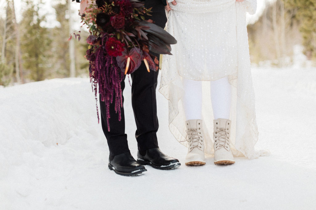 couple eloping in Breckenridge, Colorado during the winter , showing their Timberland boots with their moody bouquet from the Perfect Petal