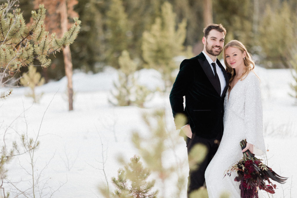couple eloping in Breckenridge, Colorado during the winter smiling and looking at the camera