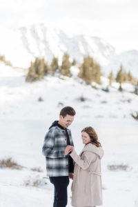 Woman looking at her new engagement ring still in shock after surprise mountaintop proposal on Loveland Pass in Breckenridge, Colorado.
