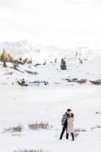 Recently engaged couple kissing on a mountaintop after surprise proposal on Loveland Pass in Breckenridge, Colorado.
