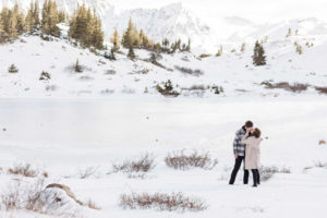 Recently engaged couple kissing on a mountaintop after surprise proposal on Loveland Pass in Breckenridge, Colorado.