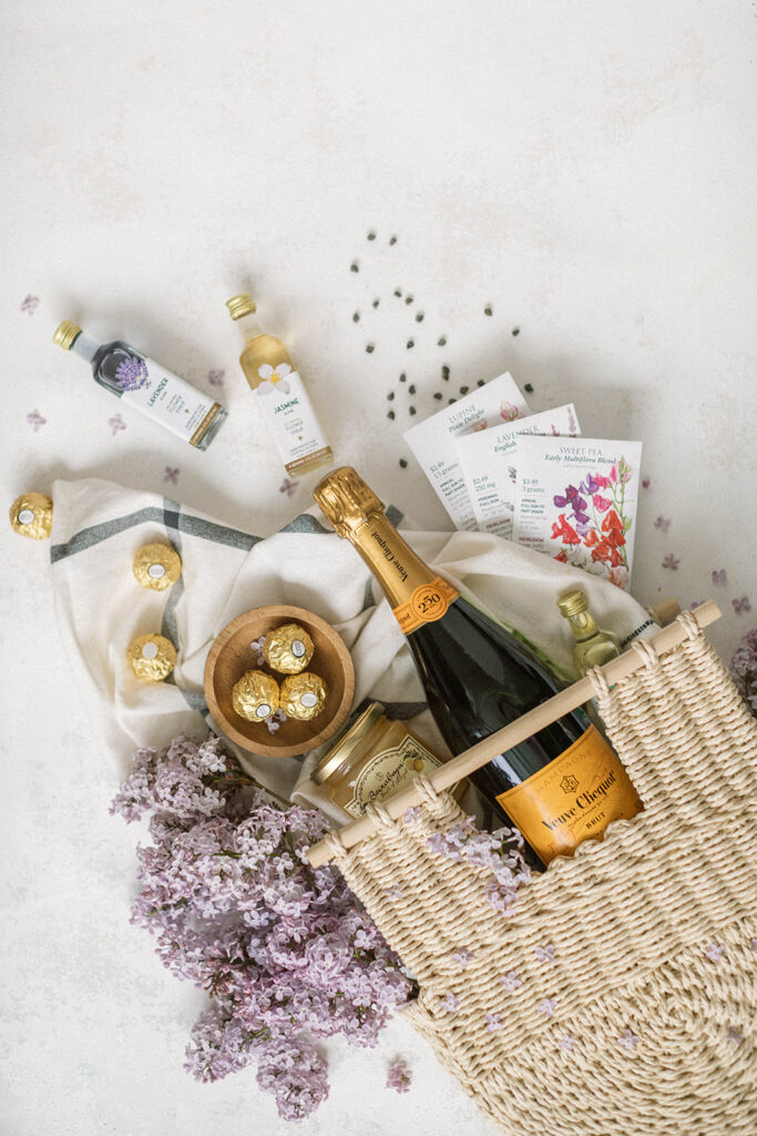 italian inspired welcome bag for luxury destination wedding couples having a france wedding with a loaf of bread, vueve cliquot, floral syrups, and floral seed packets by destination wedding photographer Diana Coulter at Greystone Castle in Boulder, CO