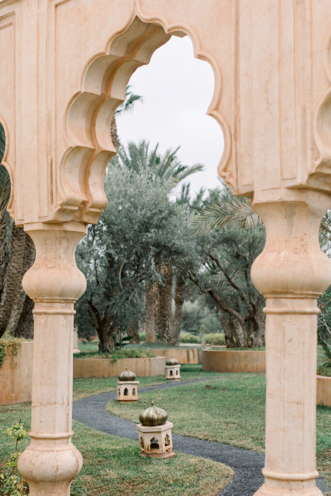 a view of the pal trees through the arches at Palais Namaskar, a luxury Morocco Wedding venue